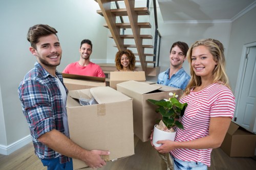 Removal company staff loading boxes and furniture into a van